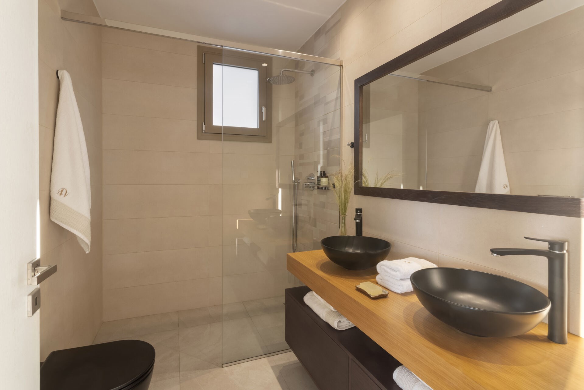 A modern en-suite shower room, finished in soft, natural materials.