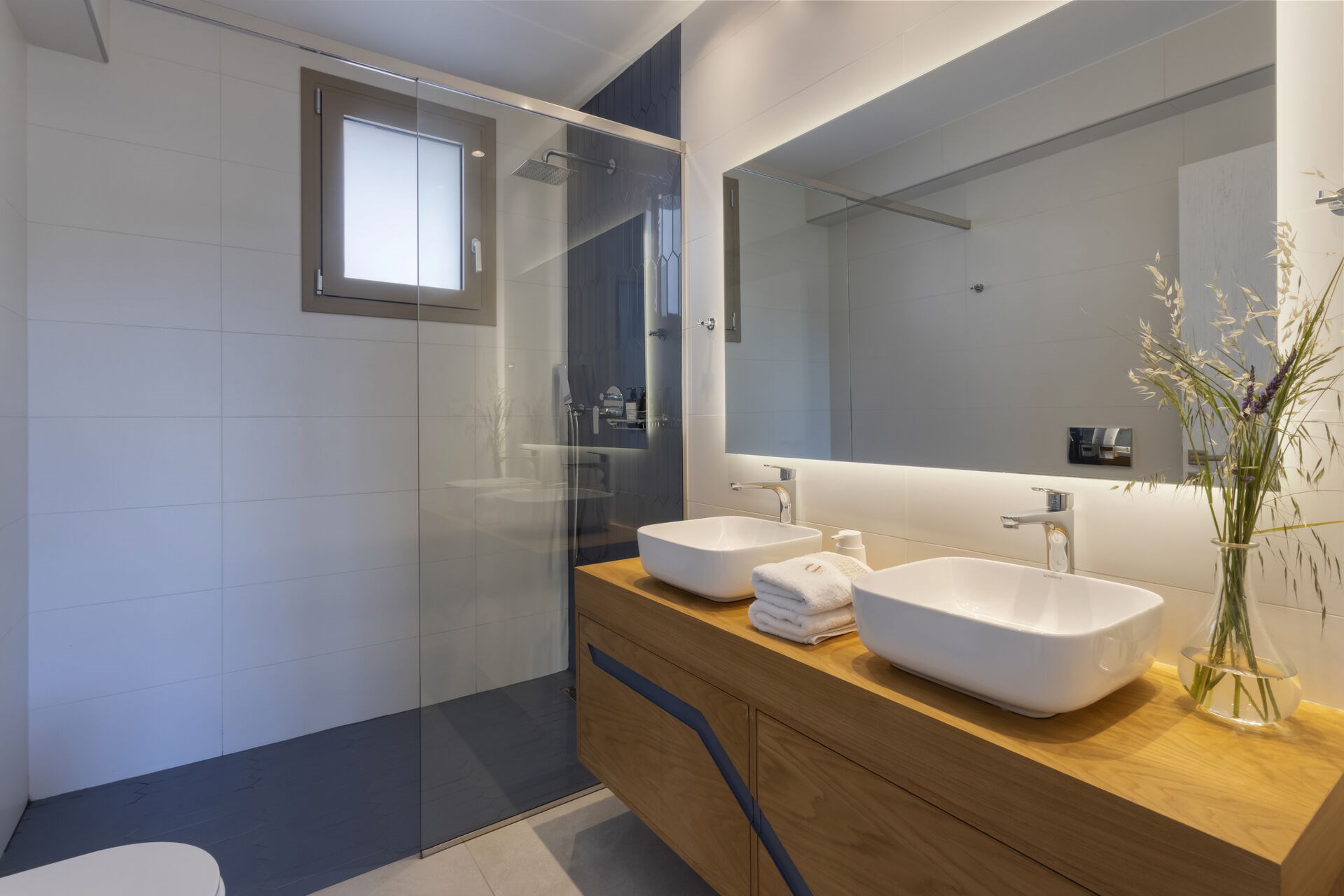 A modern en-suite shower room, finished in soft, natural materials.
