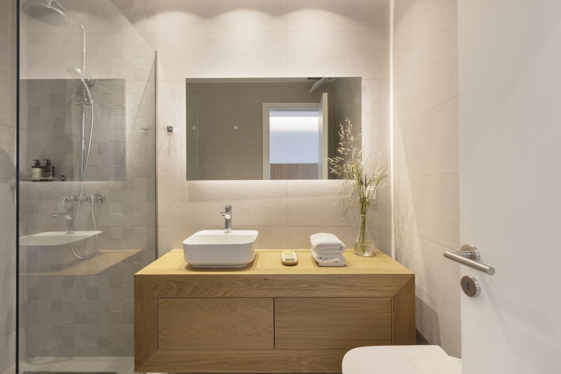 A modern en-suite shower room, finished in soft, natural materials.