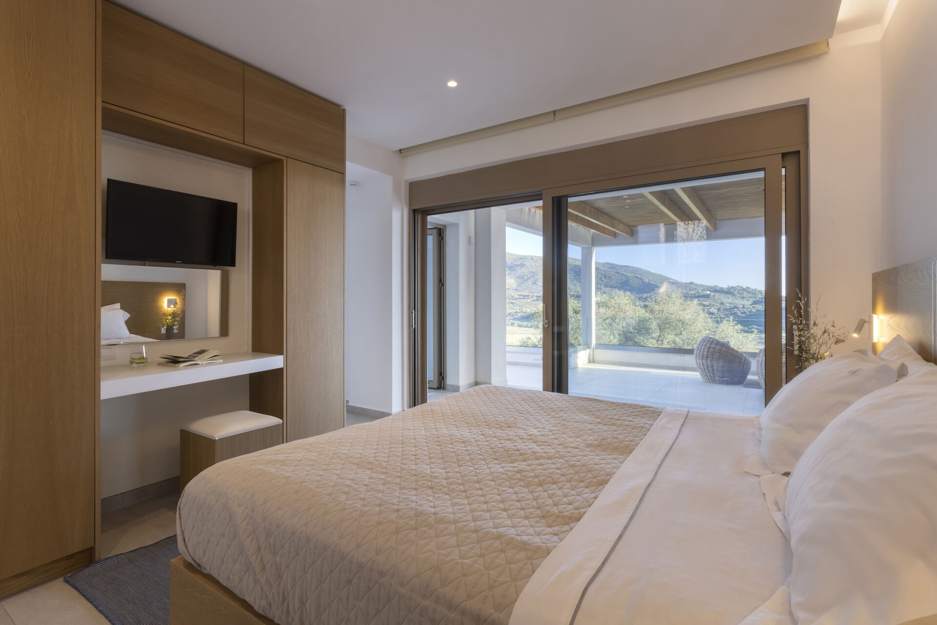 One of the villa's five bedrooms, opening onto the shared terrace with views over Keri Bay.