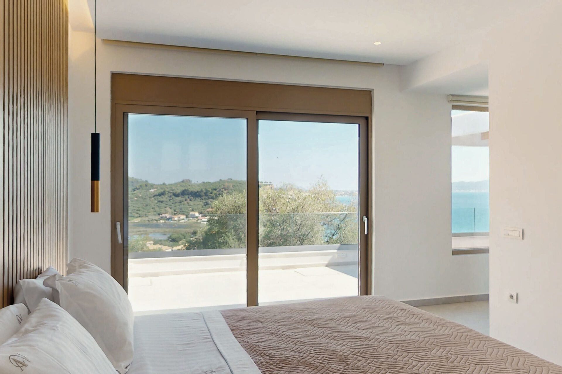 One of the villa's five bedrooms, opening onto the shared terrace with views over Keri Bay.