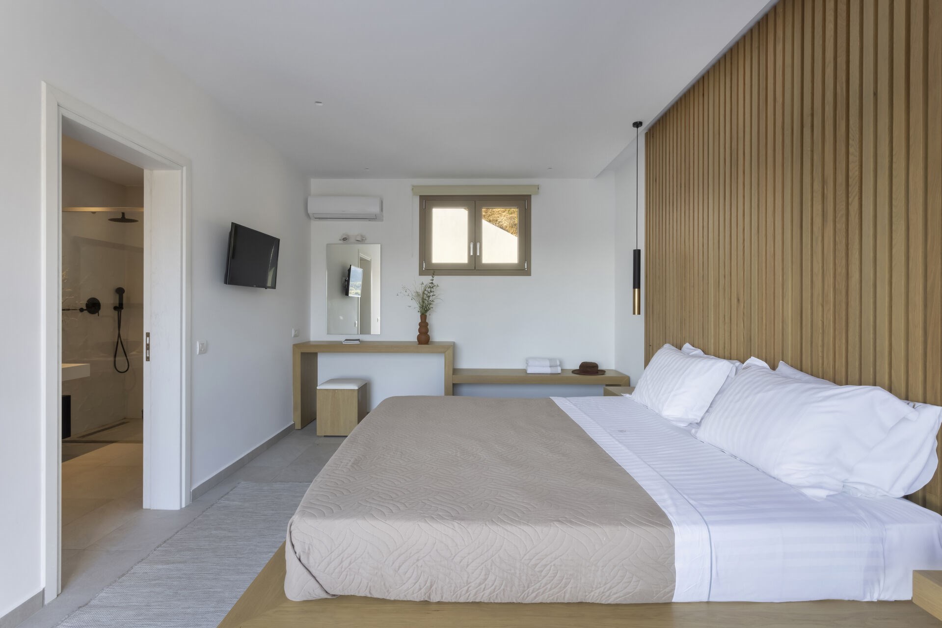One of the villa's five bedrooms, opening onto the shared terrace with views over Keri Bay.