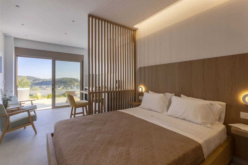 One of the villa's five bedrooms, opening onto the shared terrace with views over Keri Bay.